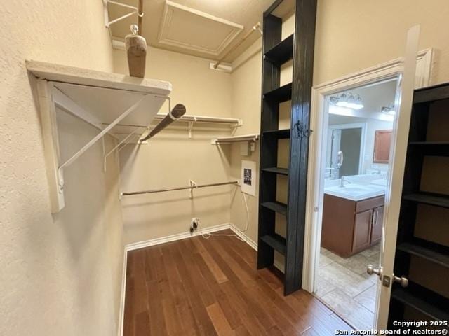 walk in closet featuring dark wood finished floors and attic access