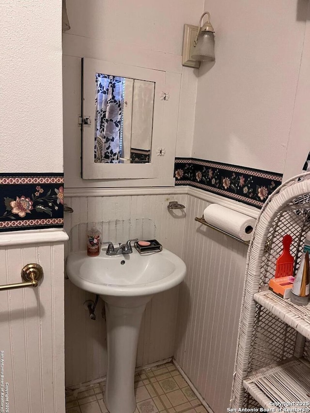 bathroom with tile patterned floors and wainscoting