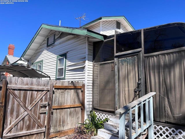 view of side of home featuring fence