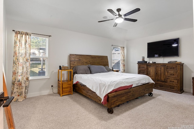 carpeted bedroom with ceiling fan and baseboards