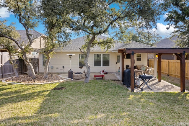 back of property with a patio, a yard, roof with shingles, and a fenced backyard