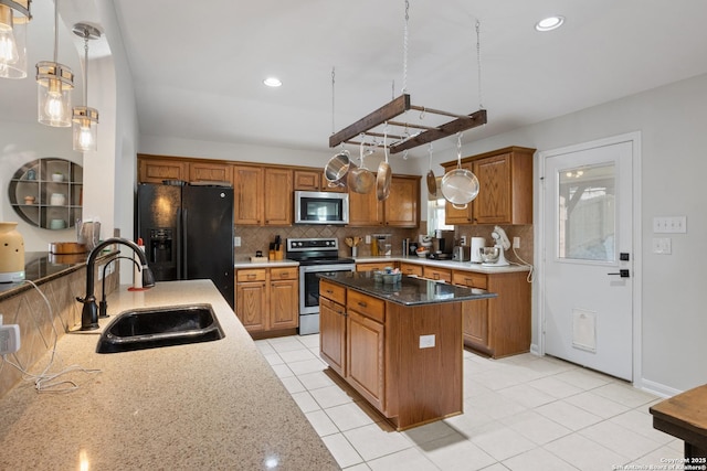 kitchen with stainless steel appliances, backsplash, a sink, and brown cabinets