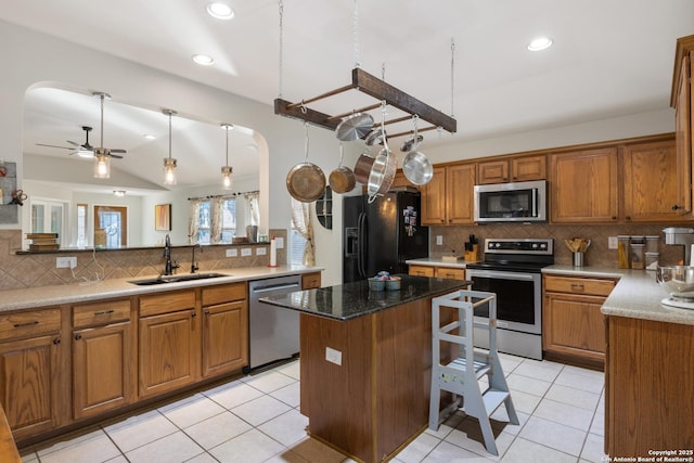 kitchen featuring brown cabinets, stainless steel appliances, and a sink