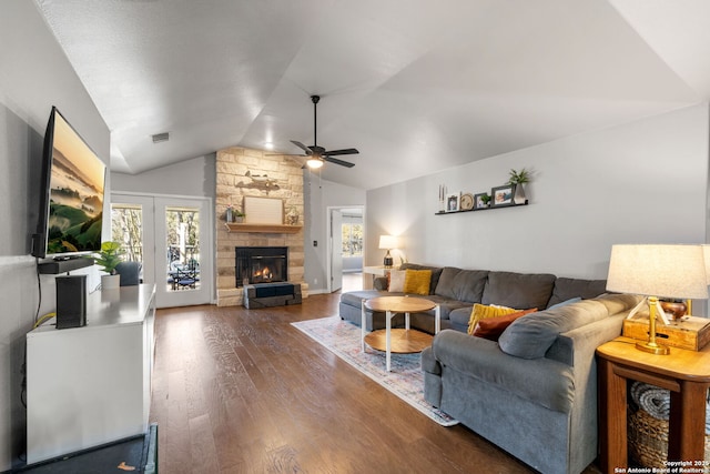 living area with dark wood-style floors, plenty of natural light, a fireplace, and vaulted ceiling