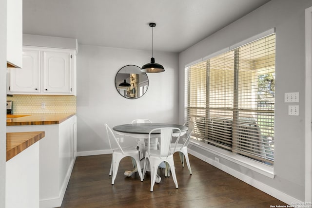 dining area with dark wood-style flooring and baseboards