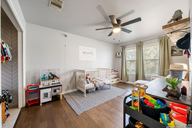 bedroom featuring a ceiling fan, wood finished floors, visible vents, and baseboards