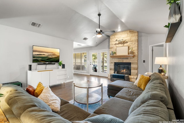 living room featuring lofted ceiling, a fireplace, wood finished floors, visible vents, and a ceiling fan