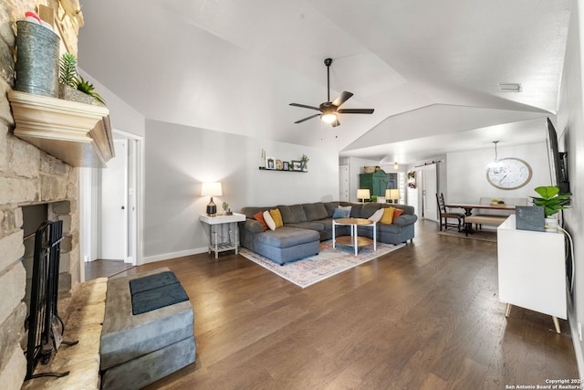 living room featuring a fireplace, lofted ceiling, visible vents, a ceiling fan, and wood finished floors