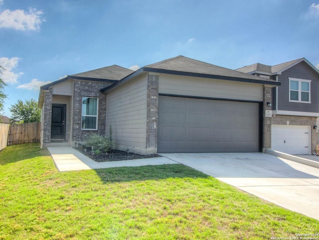 view of front of property with brick siding, fence, a garage, driveway, and a front lawn