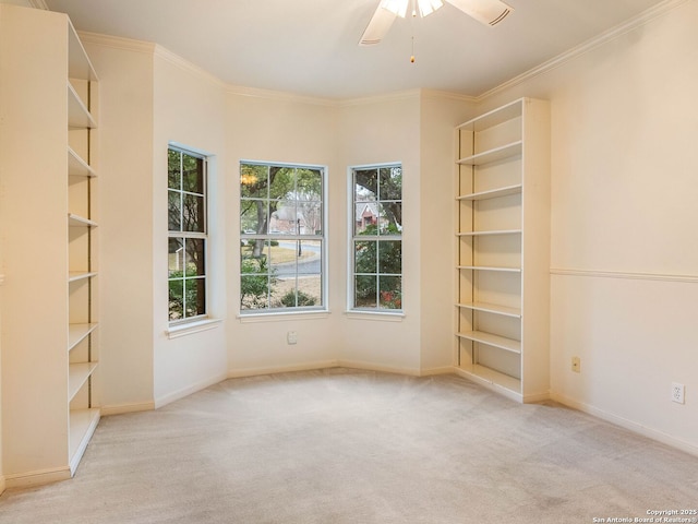 empty room featuring carpet floors, crown molding, baseboards, and ceiling fan