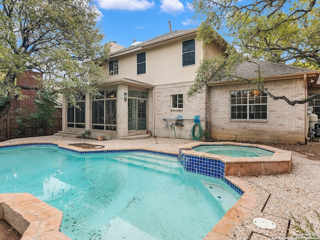 view of swimming pool with a pool with connected hot tub, a sunroom, and fence