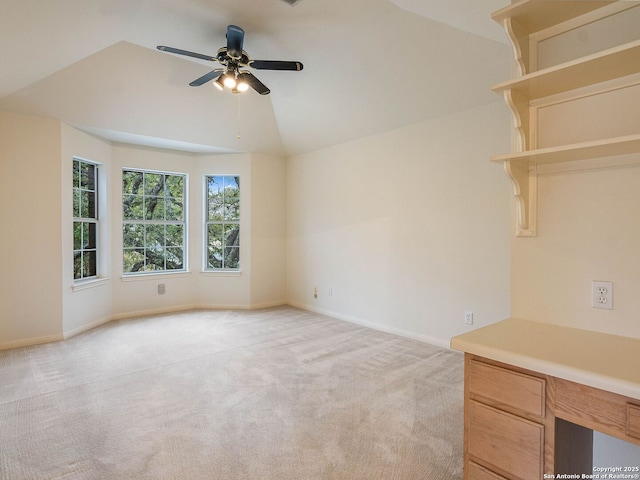 empty room with lofted ceiling, light colored carpet, ceiling fan, and baseboards