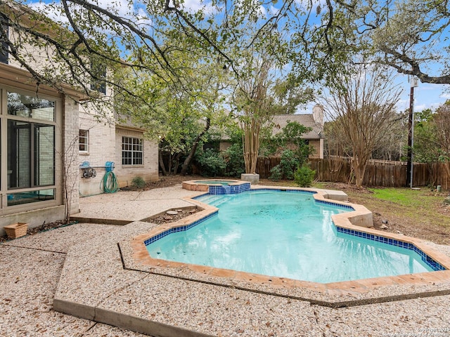 view of swimming pool featuring a patio area, a fenced backyard, and a pool with connected hot tub