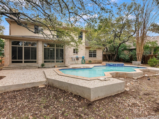 view of swimming pool with a pool with connected hot tub, fence, and a patio