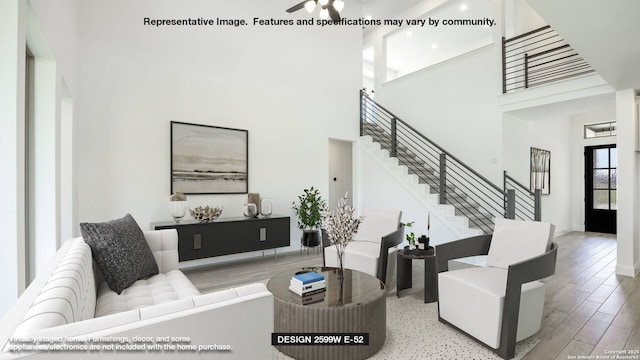 living area featuring a high ceiling, stairway, and wood finished floors