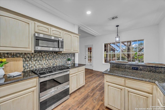 kitchen with visible vents, light brown cabinets, appliances with stainless steel finishes, and decorative backsplash