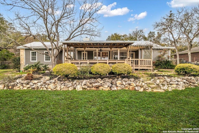 rear view of property featuring a deck and a lawn