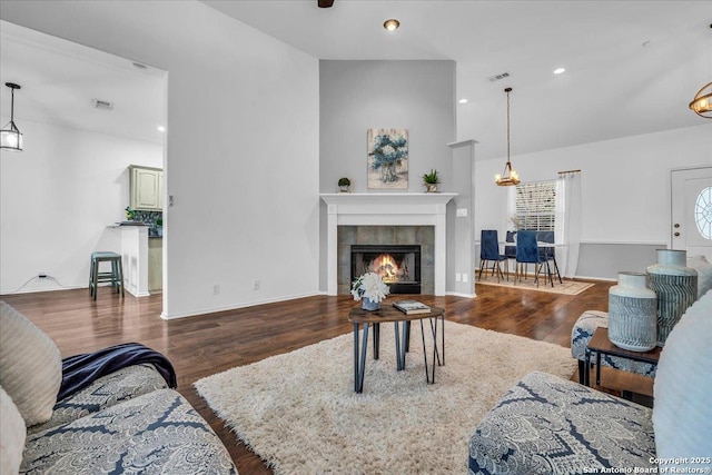 living area featuring a tiled fireplace, visible vents, wood finished floors, and recessed lighting