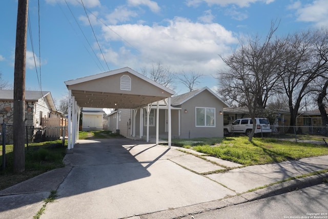 view of front of property with fence, concrete driveway, and stucco siding