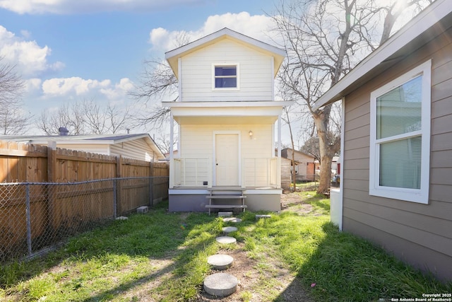 rear view of house featuring a fenced backyard