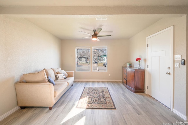 living room with baseboards, light wood-type flooring, visible vents, and a ceiling fan