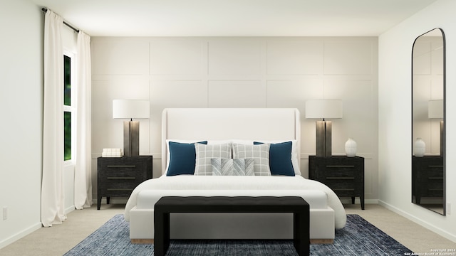 bedroom featuring baseboards, light colored carpet, and a decorative wall