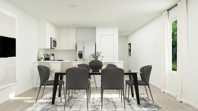 kitchen featuring light wood-style flooring, white refrigerator with ice dispenser, white cabinetry, and baseboards