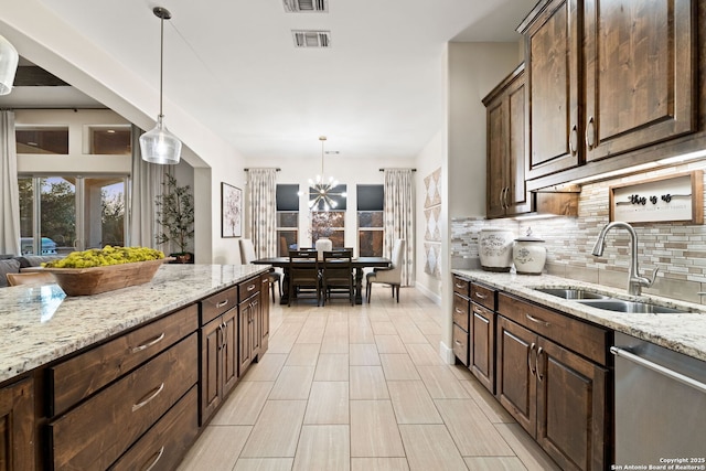 kitchen with dishwasher, visible vents, backsplash, and a sink