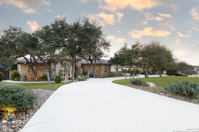 view of front of property with concrete driveway and a lawn