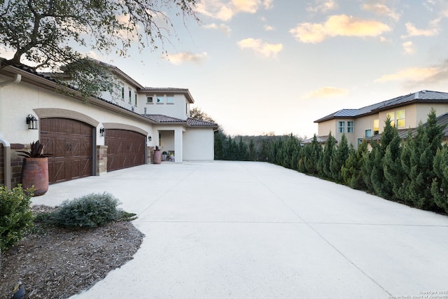 view of home's exterior featuring a garage, concrete driveway, and stucco siding