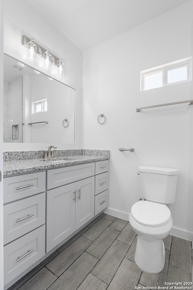 full bathroom with vanity, toilet, and baseboards