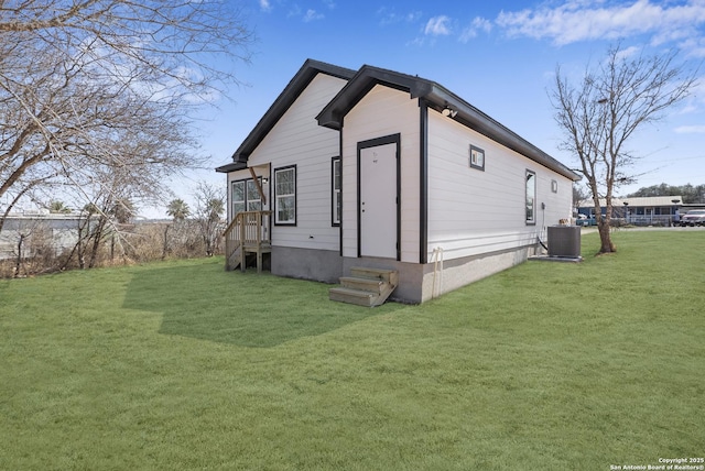 view of side of property featuring a yard and central air condition unit