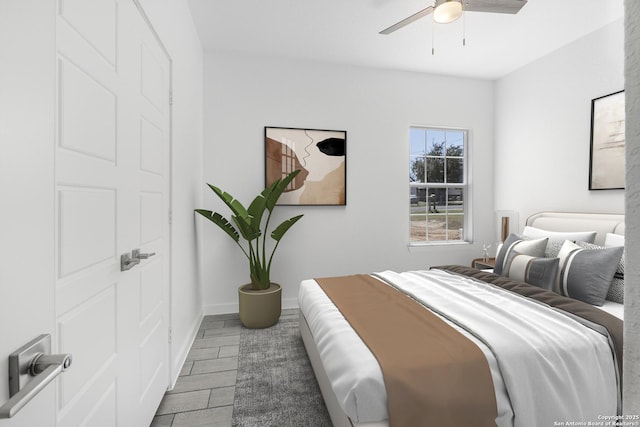 bedroom with baseboards, ceiling fan, and wood tiled floor