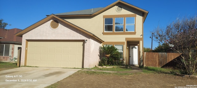 traditional-style house with brick siding, fence, driveway, and an attached garage