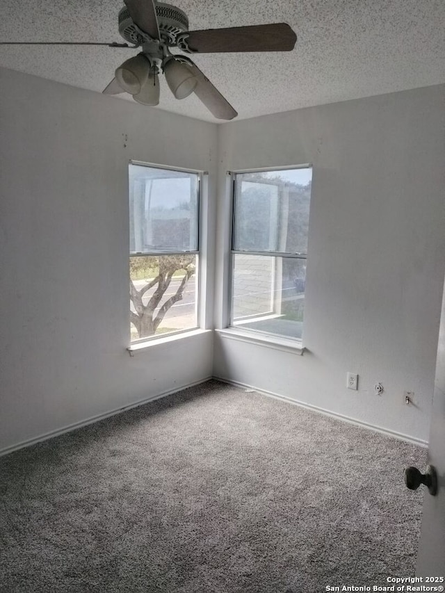 carpeted empty room with a ceiling fan, a textured ceiling, and baseboards