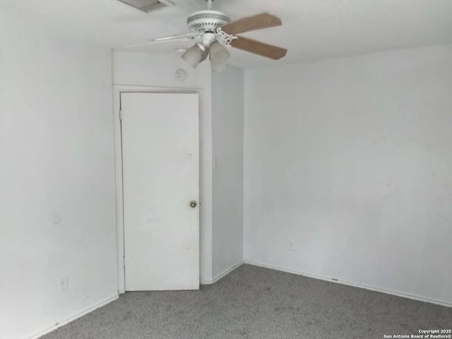 carpeted spare room featuring ceiling fan