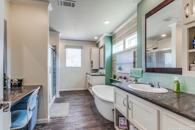 bathroom with a stall shower, visible vents, wood finished floors, crown molding, and vanity