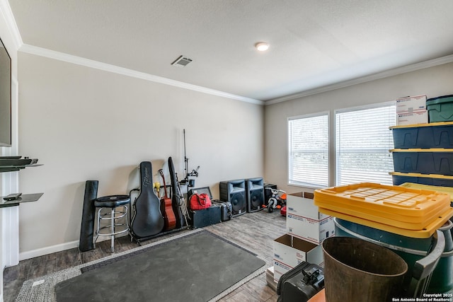 playroom with visible vents, crown molding, and wood finished floors