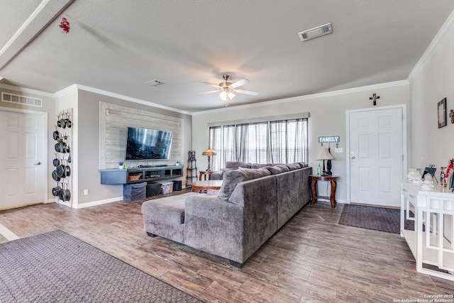 living area with crown molding, visible vents, ceiling fan, and wood finished floors