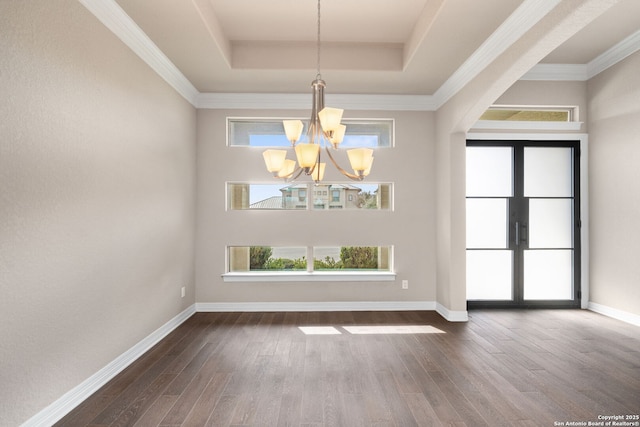 unfurnished dining area featuring dark wood-type flooring, a raised ceiling, baseboards, and french doors