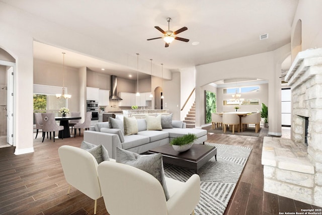 living room with arched walkways, a wealth of natural light, visible vents, and wood tiled floor