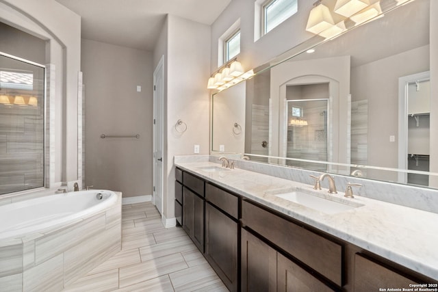 full bath with a stall shower, double vanity, a sink, and a bath