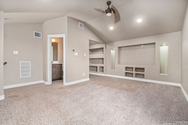 carpeted cinema room with built in shelves, visible vents, and ceiling fan