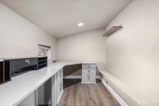 home office with built in desk, wood finished floors, and baseboards