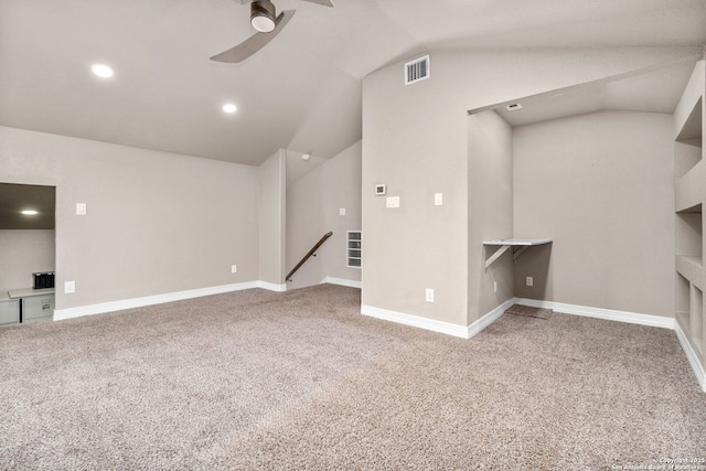 unfurnished living room featuring a ceiling fan, carpet, visible vents, and vaulted ceiling