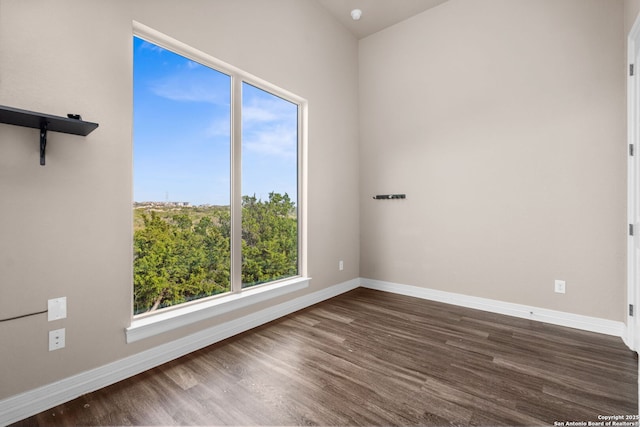 empty room with baseboards and dark wood-style flooring