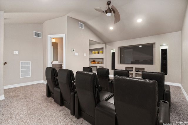 cinema room with lofted ceiling, ceiling fan, and visible vents