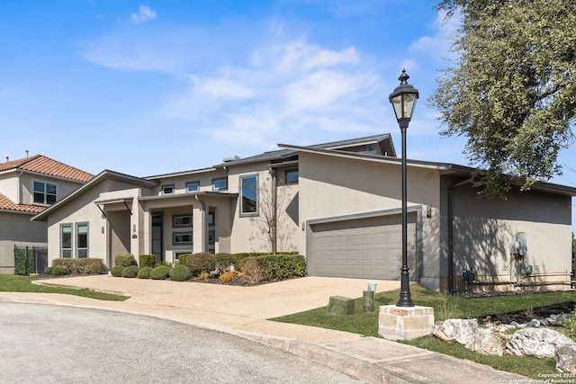 view of front of home featuring a garage, driveway, and stucco siding