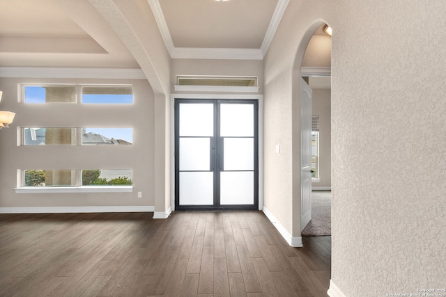 foyer with baseboards, arched walkways, ornamental molding, dark wood-style flooring, and french doors