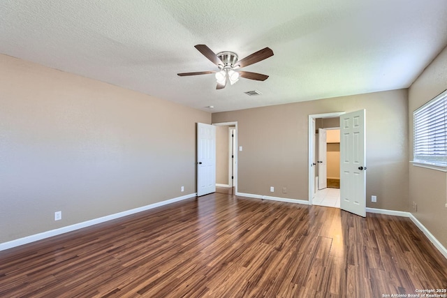 unfurnished bedroom with baseboards, a textured ceiling, visible vents, and wood finished floors